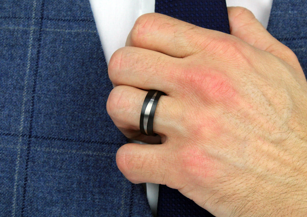 Model wearing Black Carbon Fibre Ring with Titanium Wave, 7mm wide, 2.5 mm deep, Comfort court profile, 52548/001/000/2050